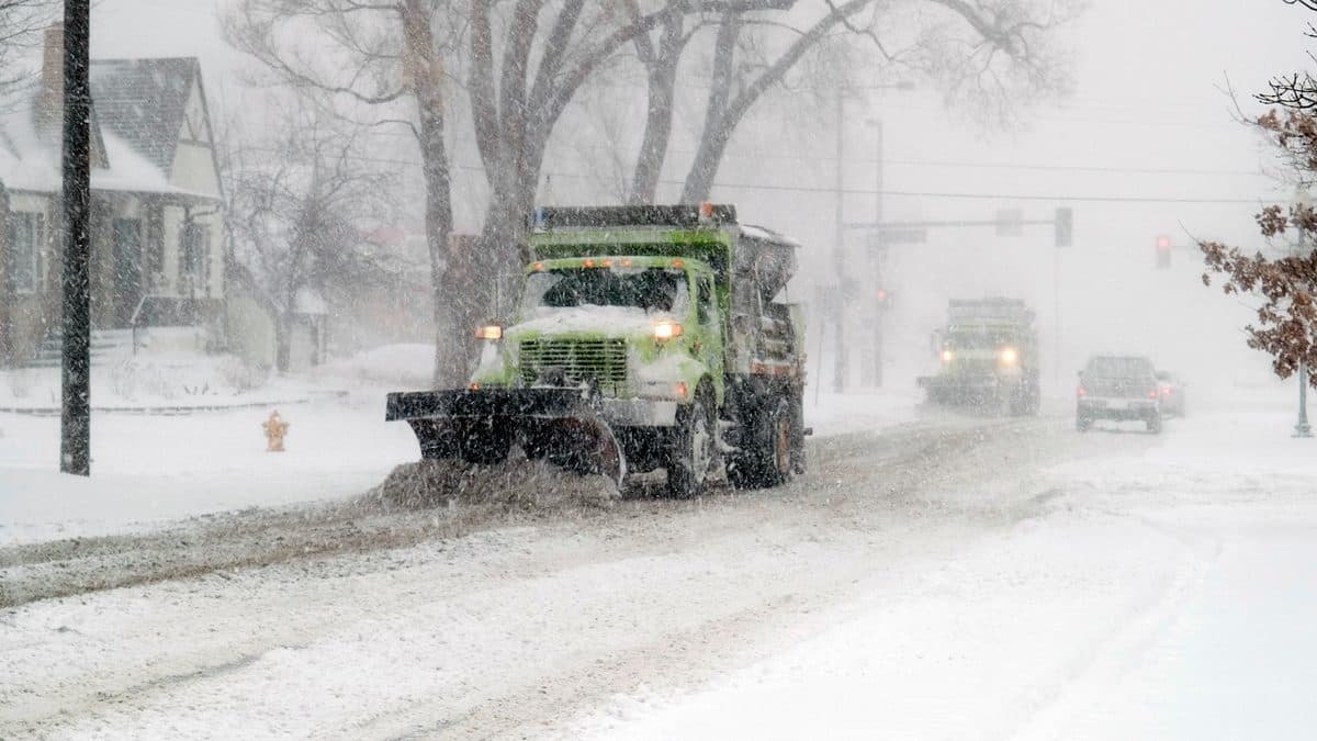 A snowplough clearing a Colorado road in heavy falling snow during a blizzard