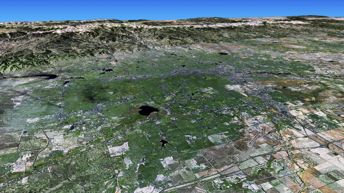 Satellite view of Denver, Colorado, with the snow-capped Rocky Mountains rising immediately to the west