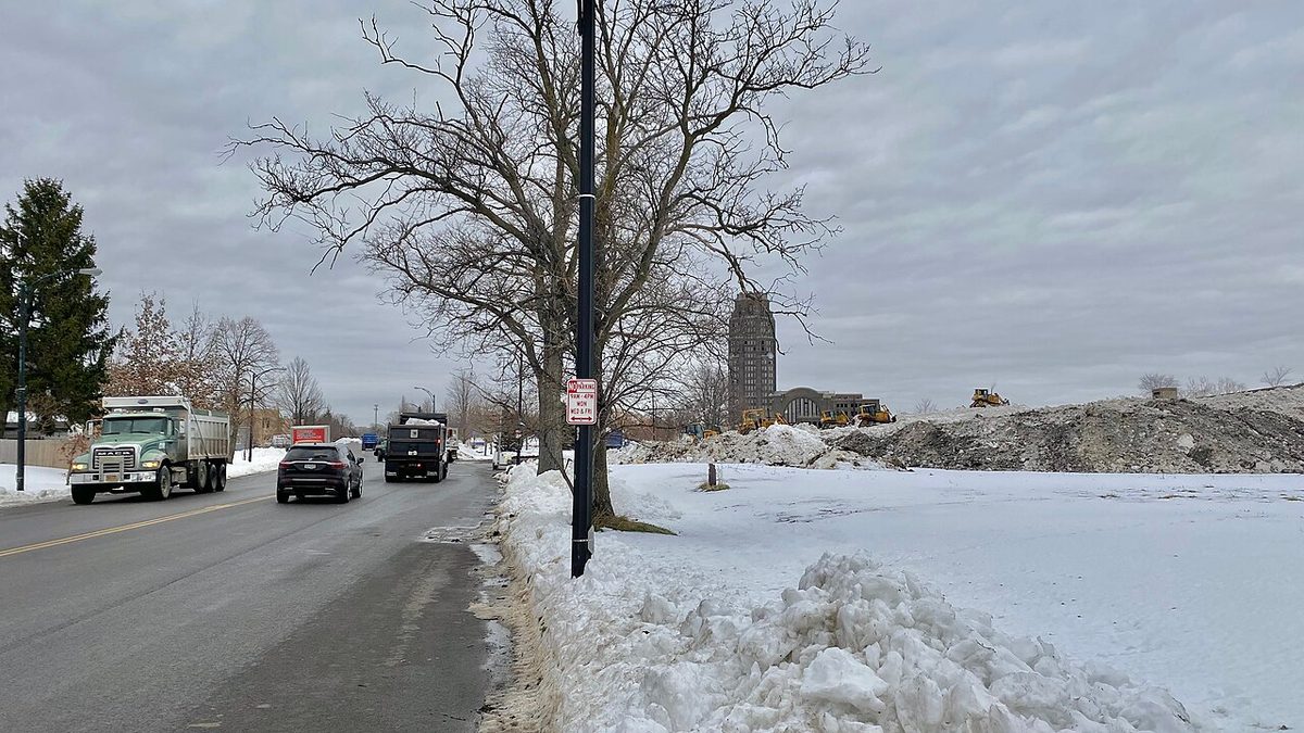 Dump trucks unloading snow at Central Terminal after the December 2022 Buffalo blizzard, with the terminal's tower visible in the background