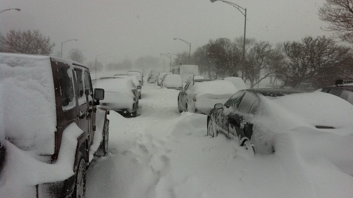Cars stuck in deep snow on Lake Shore Drive in Chicago during a blizzard, with drifts burying vehicles on the roadway