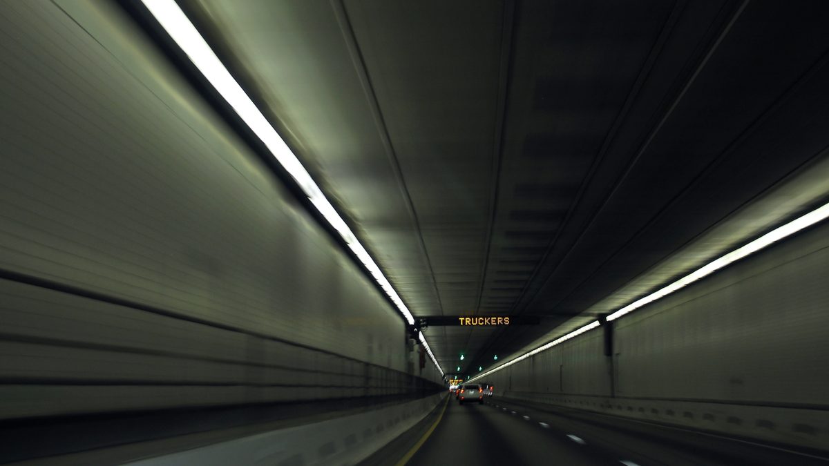 Westbound Interstate 70 approaching the Eisenhower Tunnel in the Colorado mountains with a truckers gear down sign