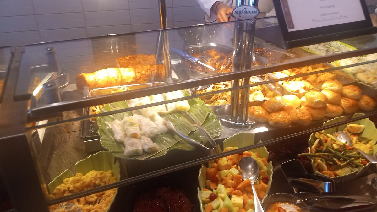 Buffet counter filled with hot dishes, salads and desserts