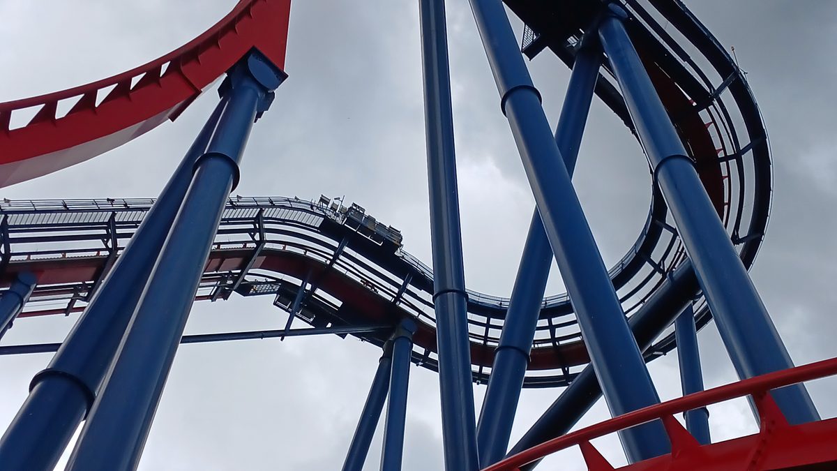Looking up at a roller coaster at a Florida theme park during a thunderstorm, with dark storm clouds overhead