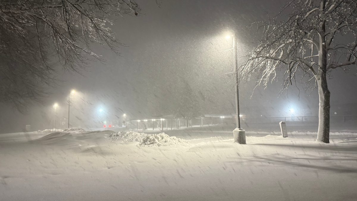 A snow-covered school parking lot at night during a winter storm in Ewing Township, Mercer County, New Jersey