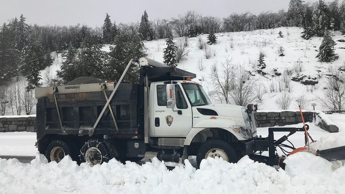 A National Park Service snow plough clearing a parking lot at Newfound Gap in deep snow in the Great Smoky Mountains