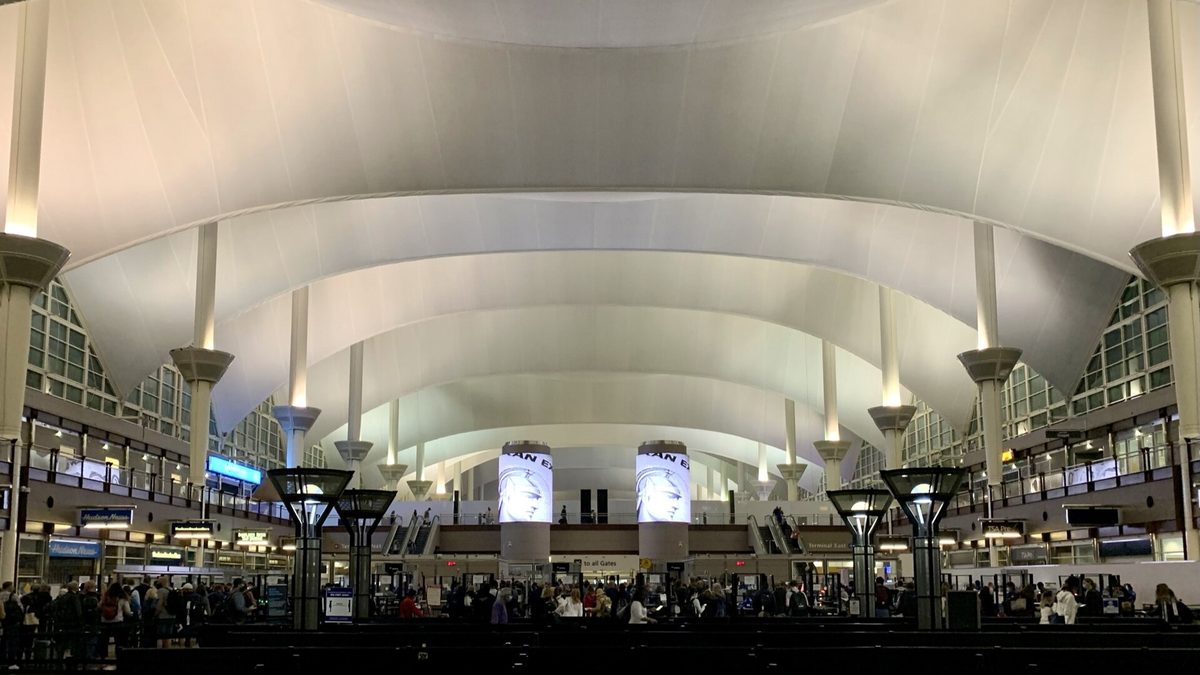 Passengers waiting in line to clear the TSA security checkpoint at Denver International Airport