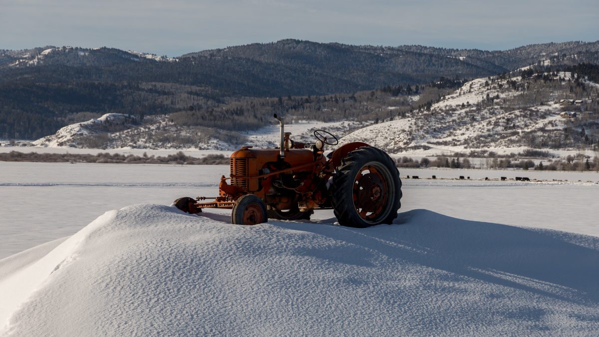 A snow-covered field with a disused tractor in Star Valley, Wyoming